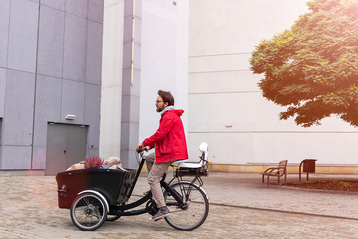 Ein Mann transportiert mit seinem Lastenfahrrad Einkäufe.