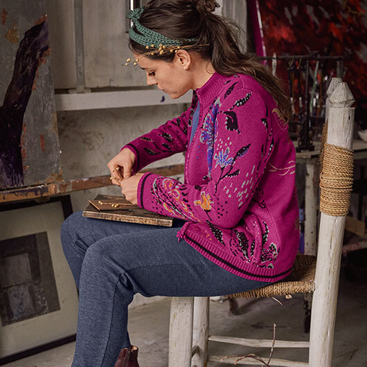 Frau in Bio-Strickjacke bastelt in der Werkstatt.