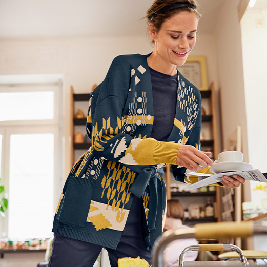 Eine Frau mit einer Strickjacke in einem Cafe