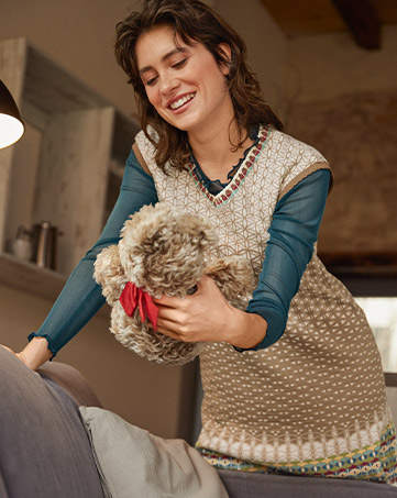 Frau in Jacquard-Strickjacke am kreativen Arbeiten.