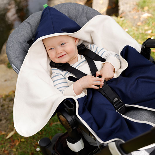 Baby in Einschlagdecke in Naturkind-Kinderwagen von Waschbär
