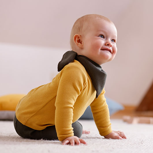 Baby in gelbem Langarm-Rippshirt von Waschbär